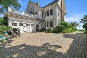 a large white house with a brick driveway at Gorgeous Historical Mansion on the Lake Front in Racine
