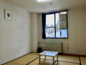 a room with a table in front of a window at 千丈温泉 ペンシオーネセイモア サウナはくさん SENJO Onsen PENSIONE SEYMOUR Sauna Hakusan in Hakusan +68 photos