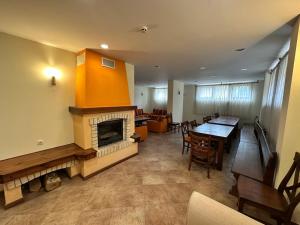 ein Wohnzimmer mit Kamin und ein Esszimmer in der Unterkunft St Ivan Rilski Spa & Pool Getaway in Bansko