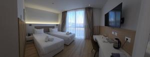 a hotel room with two beds and a television at Metro Hotel Terminal in Tirana
