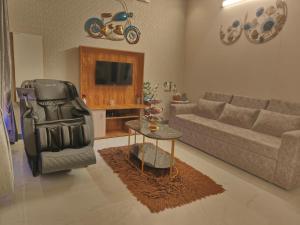 a living room with a couch and a chair and a table at UDUPI HOMESTAY CHALET LA BONNE Vie in Udupi