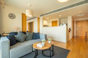 salon z niebieską kanapą i stołem w obiekcie Stylish 1BR Retreat Al Sana, Al Raha Beach w Abu Zabi