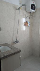 a bathroom with a shower with a sink and a fan at Seneh Homes in Guwahati
