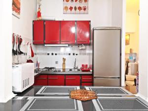 a kitchen with red cabinets and a stainless steel refrigerator at Casita Arenal in El Arenal