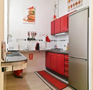 a kitchen with red cabinets and a stainless steel refrigerator at Casita Arenal in El Arenal