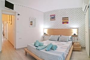 a bedroom with a bed with blue pillows on it at Casita Arenal in El Arenal