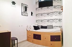 a bed in a room with a wall with writing on it at Casita Arenal in El Arenal