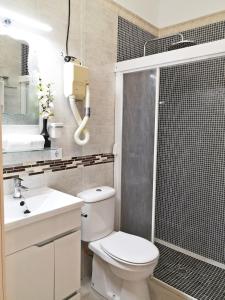 a bathroom with a toilet and a shower and a sink at Casita Arenal in El Arenal +5 photos