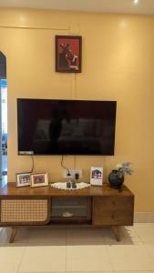 a large flat screen tv on a yellow wall at Seneh Homes in Guwahati