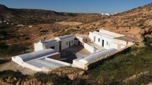 a white building in the middle of a mountain at Dar Jeddi in Kreddache