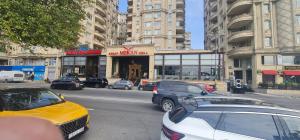 a busy city street with cars parked in front of a building at Tsentr Geidar Aliev Apartment in Baku