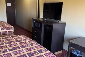 a hotel room with two beds and a flat screen tv at Broadway INN & SUITES OKC in Oklahoma City +14 photos