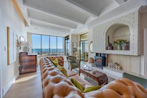 a living room with a large couch and a fireplace at HOME-LYNN, 4 bedroom, Bloubergstrand in Bloubergstrand