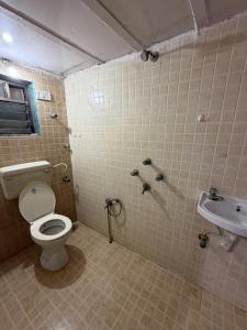 une salle de bains avec toilettes et lavabo dans l'établissement Cozy Madh Island Cottage with Private Courtyard, à Jāmb