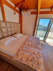 Duplex penthouse في Polisi i Vogël: سرير في غرفة ذات نافذة كبيرة