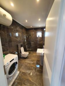 Duplex penthouse في Polisi i Vogël: حمام مع غسالة ومرحاض
