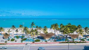 een luchtzicht op een strand met palmbomen en de oceaan bij suítes Pitanga in Maceió