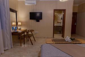 a living room with a table and a television on the wall at Tulia Boutique Hotel & Spa in Arusha