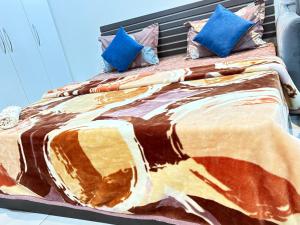 诺伊达Amigos Stays的一张大床,配有色彩缤纷的毯子和枕头