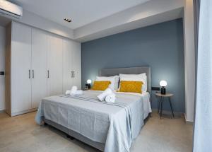 a bedroom with a large bed with yellow pillows at Aether, Light Modern Living in Gaïtánion