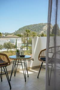 a table and chairs on a balcony with a view at Aether, Light Modern Living in Gaïtánion