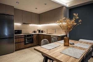 a kitchen with a wooden table and a refrigerator at Aether, Light Modern Living in Gaïtánion