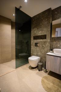 a bathroom with a toilet and a sink and a shower at Aether, Light Modern Living in Gaïtánion +30 photos