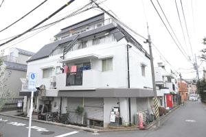 a white building with clothes hanging on a balcony at Ayame Building in Tokyo