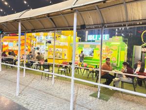 诺伊达Amigos Stays的一群坐在餐桌旁的食品车上的人