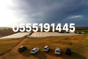 un groupe de voitures garées devant un grand panneau dans l'établissement Lush 25 Acre Farm Stay I, Play & Serenity, à Al Ḩamrānīyah