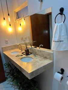 ein Badezimmer mit zwei Waschbecken und einem großen Spiegel in der Unterkunft Casa PWG Cânions - Sua casa de temporada no paraíso in Piranhas