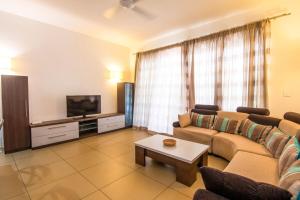 Roches NoiresにあるAzuri Ocean & Golf Village - Elegant 3-Bedroom Apartment with Private Garden, Beach & Pool Access in Roches Noiresのソファとテレビのあるリビングルーム