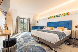 a bedroom with a large bed and a large window at Brit Hotel, Spa & Restaurant - Colmar Est in Bischwihr +125 photos