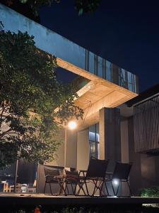 a group of chairs sitting outside of a building at night at Moonstone Villa Chiang Mai in Chiang Mai