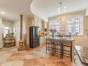 a large kitchen with a refrigerator and a stove at HOME-LYNN, 4 bedroom, Bloubergstrand in Bloubergstrand
