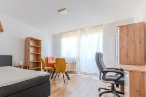 a bedroom with a bed and chairs and a desk at Danube Living Collection - Krems Wilhelm-Gause-Gasse - 90qm Apartment mit 3 Schlafzimmern in Krems an der Donau +19 photos