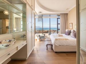 a bedroom with a large bed and a bathroom at HOME-LYNN, 4 bedroom, Bloubergstrand in Bloubergstrand
