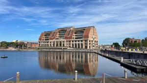 a building with a reflection in a body of water at Vue mer imprenable à Dunkerque, l'appel du large! in Dunkerque