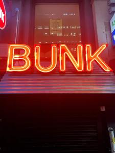 a neon sign that says burn in a store window at BOHOSTEL in Macclesfield