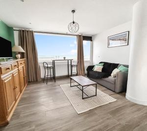a living room with a couch and a table at Vue mer imprenable à Dunkerque, l'appel du large! in Dunkerque