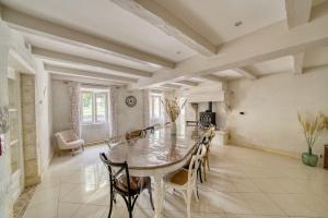 une grande salle à manger avec une table et des chaises dans l'établissement Gite de charme au milieu des vignes - La Gasconnière, à Ozillac