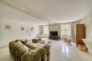 un grand salon avec un canapé et une télévision dans l'établissement Gite de charme au milieu des vignes - La Gasconnière, à Ozillac
