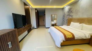 a bedroom with a large bed and a flat screen tv at Dreamy Delight in Nathia Gali