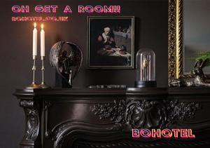 a black room with a fireplace with two candles on it at BOHOSTEL in Macclesfield +1 photo