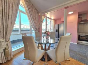Un comedor con una mesa de cristal y sillas. en Enjoy a stylish experience at this centrally-located place !, en Dublín 6 fotos más