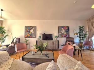 Una sala de estar con un sofá y sillas y un televisor. en Enjoy a stylish experience at this centrally-located place !, en Dublín