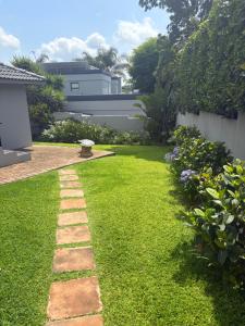 a garden with a pathway in the grass at Serenity Luxury Guesthouse in Krugersdorp