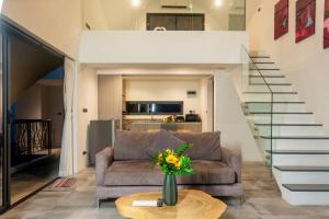 Una sala de estar con un sofá y una escalera. en Villa Seaview Majestic, en Chaweng Noi Beach