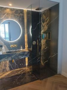 a bathroom with a black marble shower with a mirror at Antonia Luxury Home in Seville