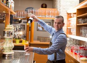 a man is making a drink in a bar at Hotel & Restaurant Waldcafe Hettstedt in Hettstedt